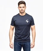 A man wearing a dark navy blue short-sleeve crewneck t-shirt with a white stylized logo on the left chest, paired with blue jeans, against a plain white background.