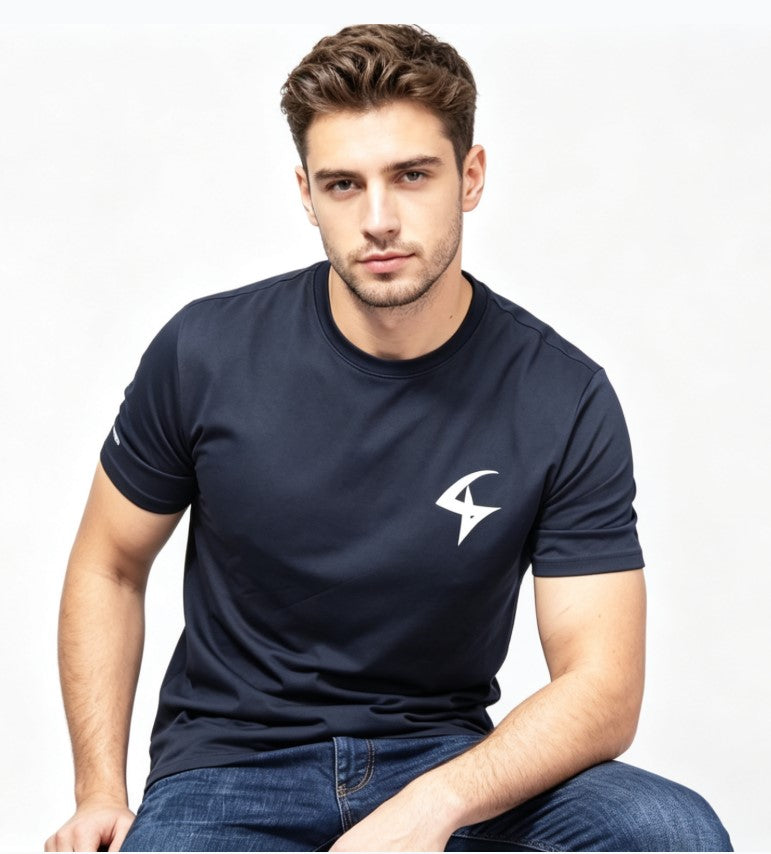 A man wearing a navy blue short-sleeve athletic t-shirt with a white stylized logo on the left chest, paired with blue jeans, photographed against a clean white background.