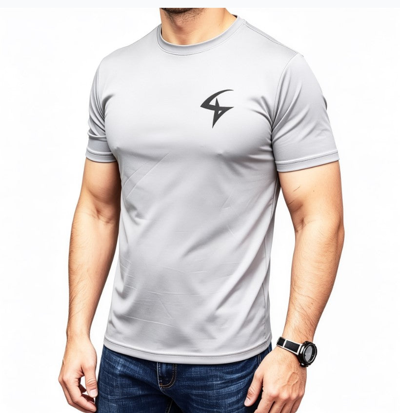 A man wearing a light gray short-sleeve athletic t-shirt with a black lightning-bolt style logo on the left chest, paired with blue jeans against a plain white background.